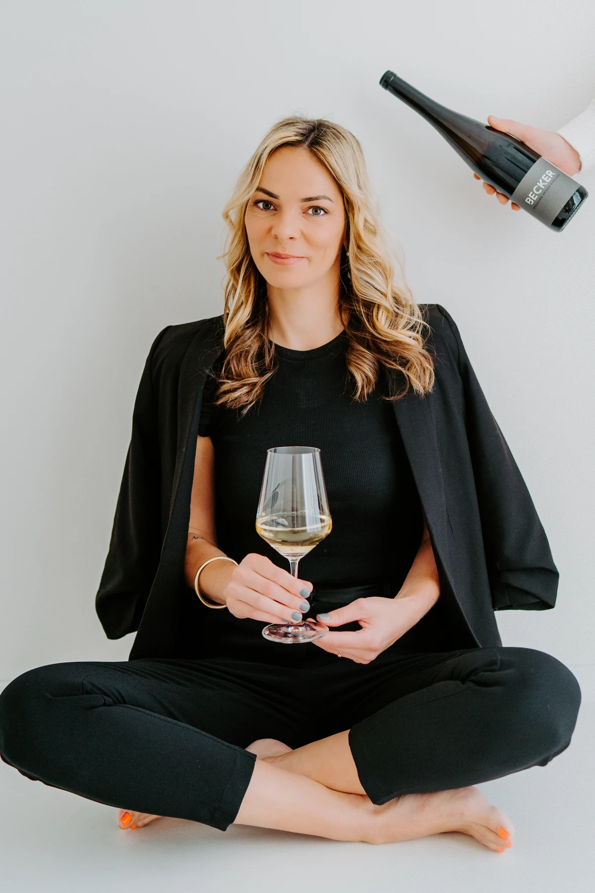 Entspanntes Businessfoto einer Unternehmerin mit Weinglas